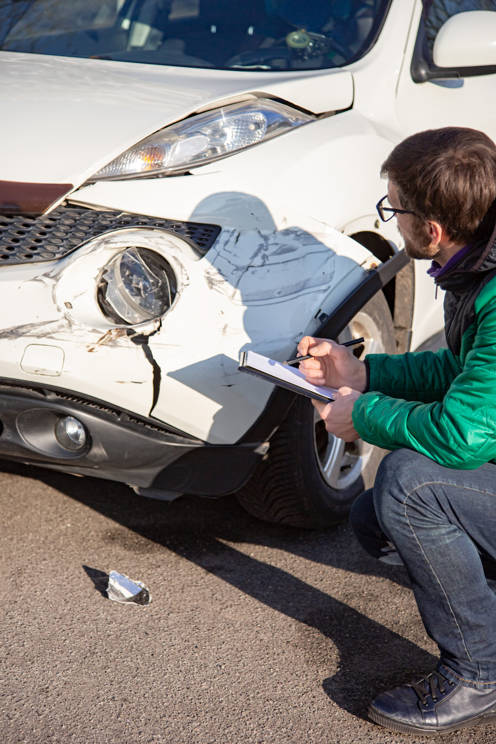 Insurance agent will examine and examine the damage to the car after an accident. Inspection of the car after an accident on the road.