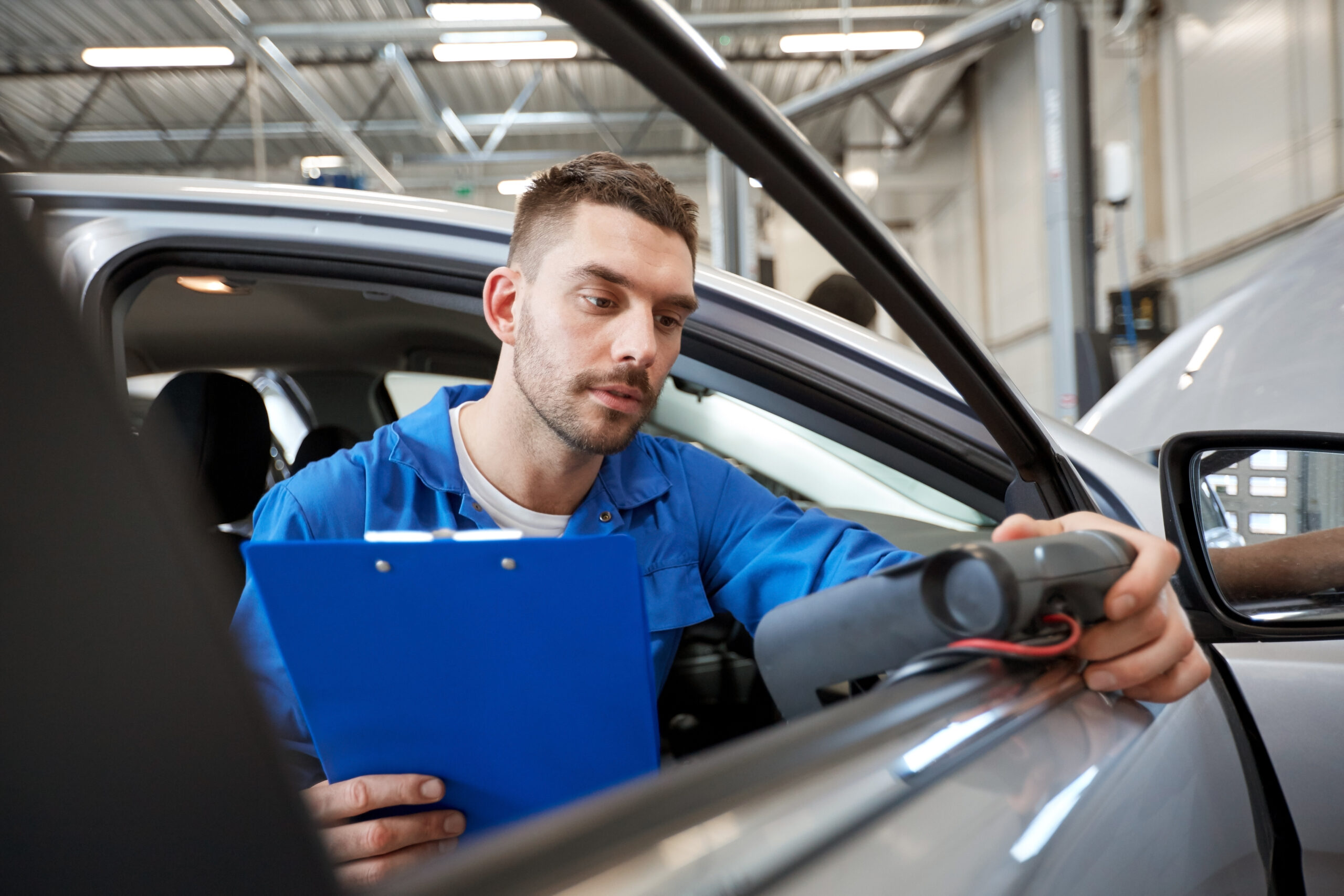 mechanic man with diagnostic scanner at car shop
